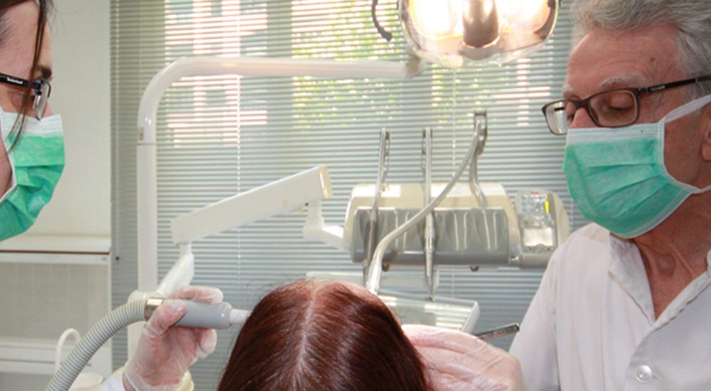 22208793 - dentist doing a dental treatment on a female patient
