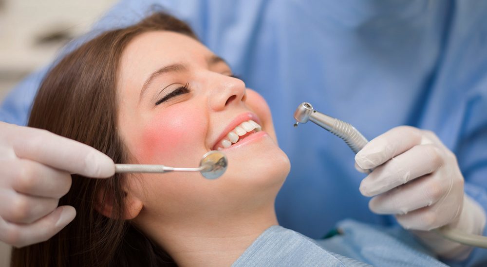 22208793 - dentist doing a dental treatment on a female patient