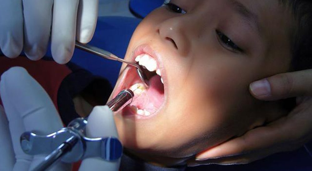 22208793 - dentist doing a dental treatment on a female patient